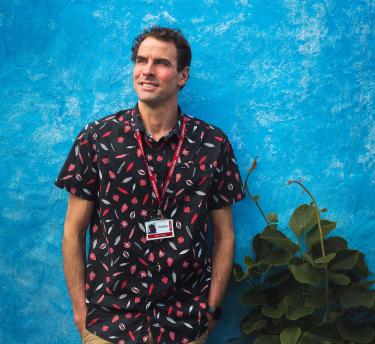 Eden employee Robbie Kirkman standing in front of a blue wall in the Mediterranean Biome